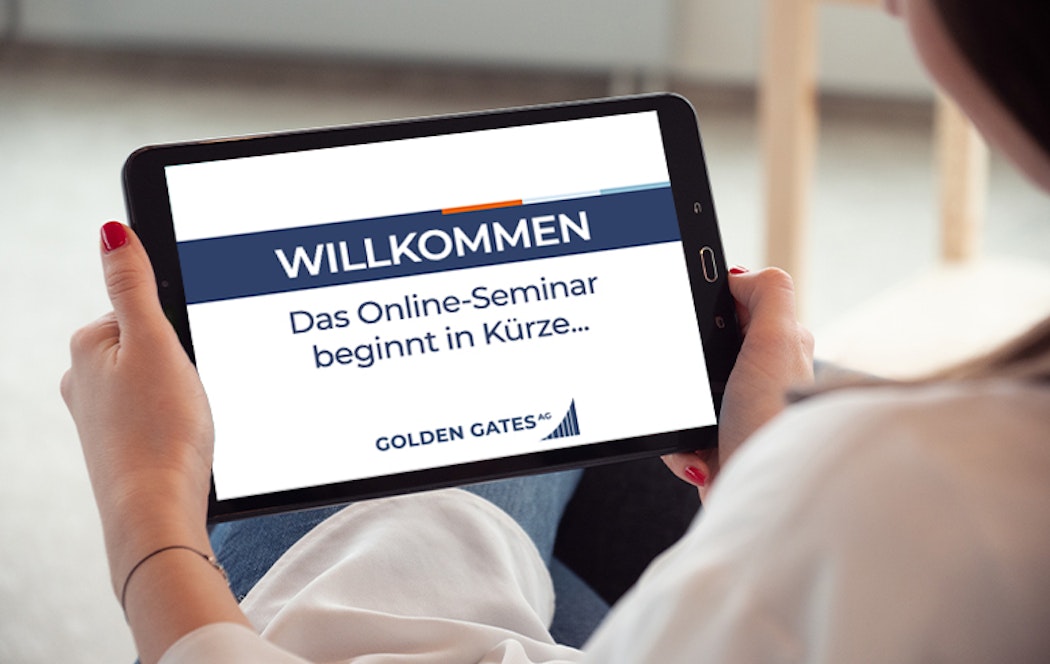 Über die Schulter einer Frau, ist der Fokus auf den Bildschirm eines Tablets gerichtet. Auf diesem steht geschrieben: "zum Video", darunter in orangener Schrift: "Jederzeit verfügbar" und unten ist das Logo der Golden Gates AG eingeblendet. Melden Sie sich zu den Golden Gates Online-Seminaren an.