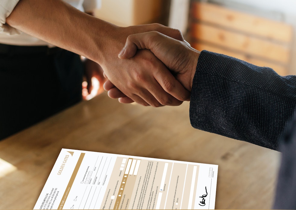 Zwei Personen, geben sich die Hand und besiegeln den Vertrag, welcher darunterliegt. Werden auch Sie Vertriebspartner der Golden Gates AG.