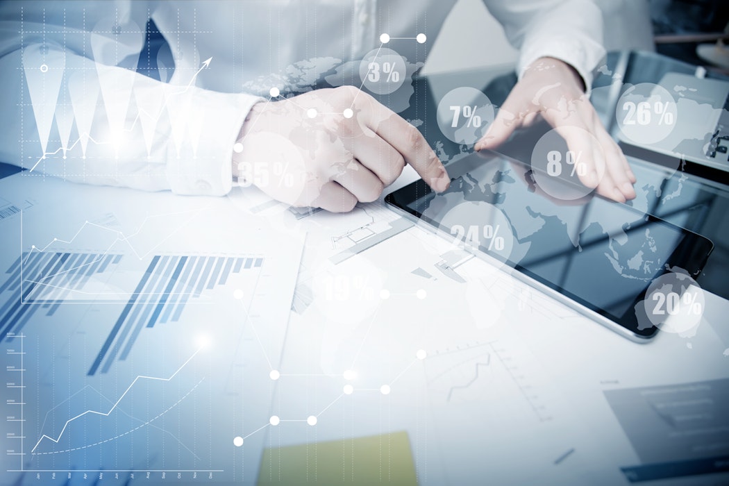 Eine Person, welche ein Tablet bedient. Neben diesem liegt auf Papier ein Blaken Diagramm. Im Vordergrund sind in Kreisen Prozentzahlen abgebildet. Werden auch Sie Vertriebspartner der Golden Gates.